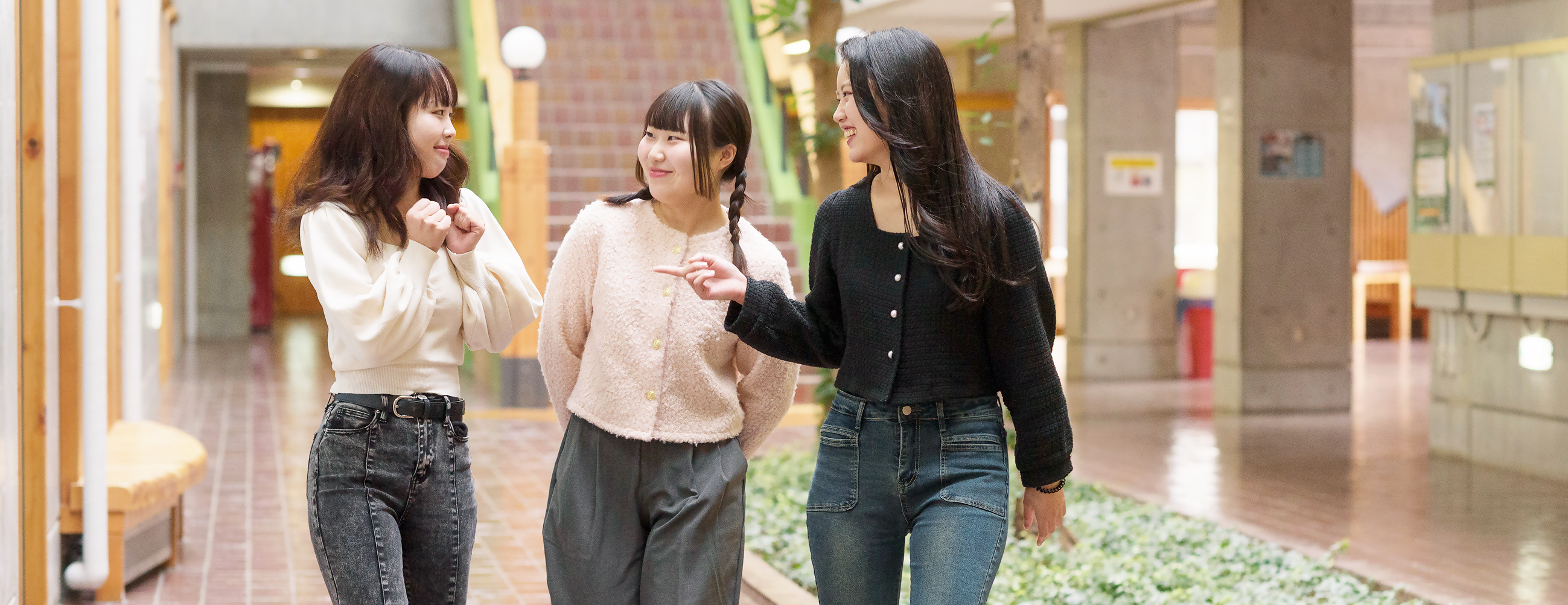 キャンパス内を歩きながら会話を楽しむ学生たちの様子の画像